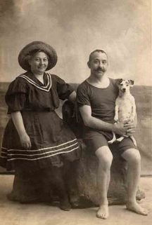 Casal na praia, com seu cachorro (foto tirada em estúdio). Final do século XIX.