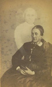 Mulher idosa não-identificada com três espíritos no fundo. Por volta de 1862-1875.